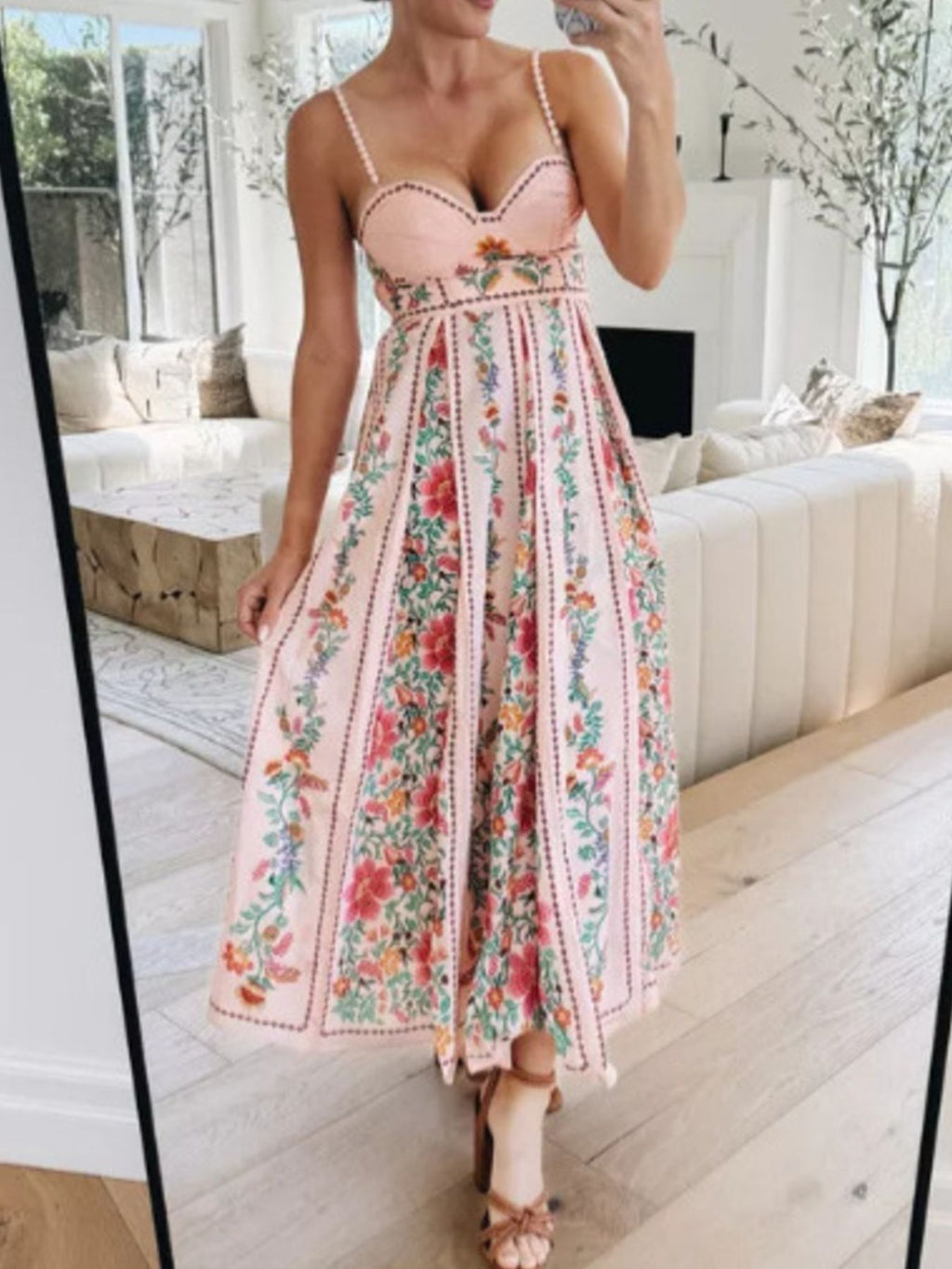 bohemian floral maxi dress in pink holding out skirt