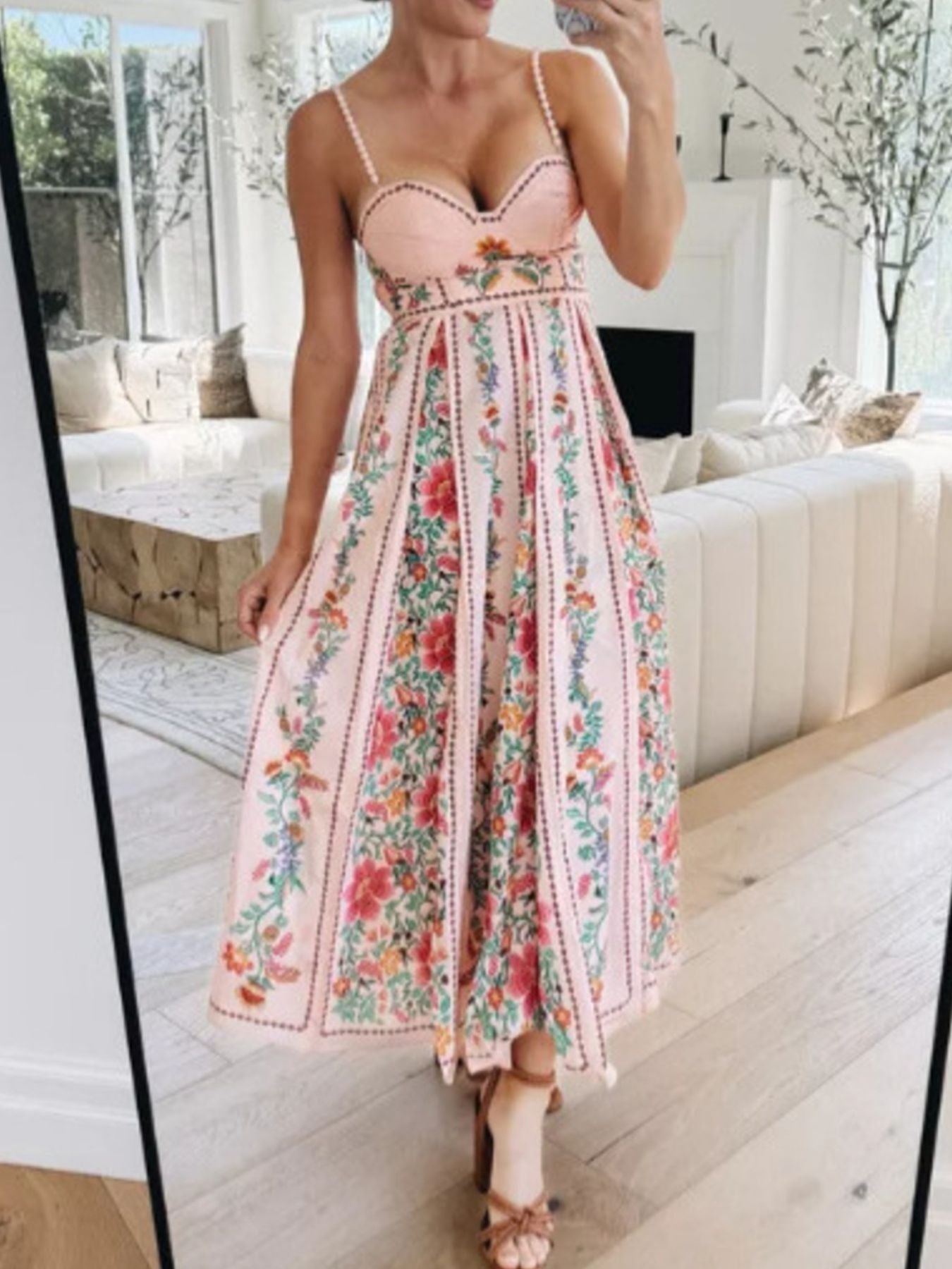 bohemian floral maxi dress in pink holding out skirt
