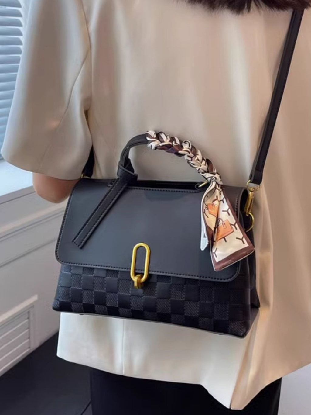 embossed crossbody bag slung over back front view