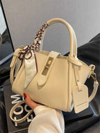 Structured mini satchel crossbody in ivory held in hand