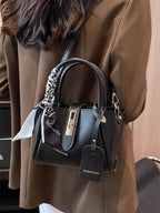 Structured mini satchel crossbody in black slung over shoulder