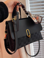 embossed crossbody bag held in hand front view