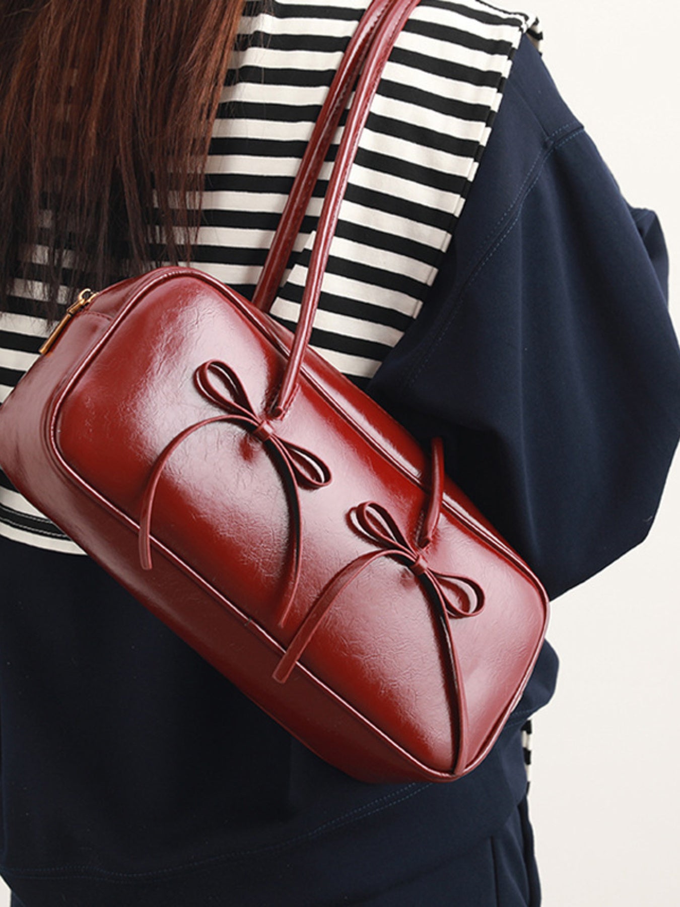 Bow decor shoulder bag with front bow detail slung over shoulder