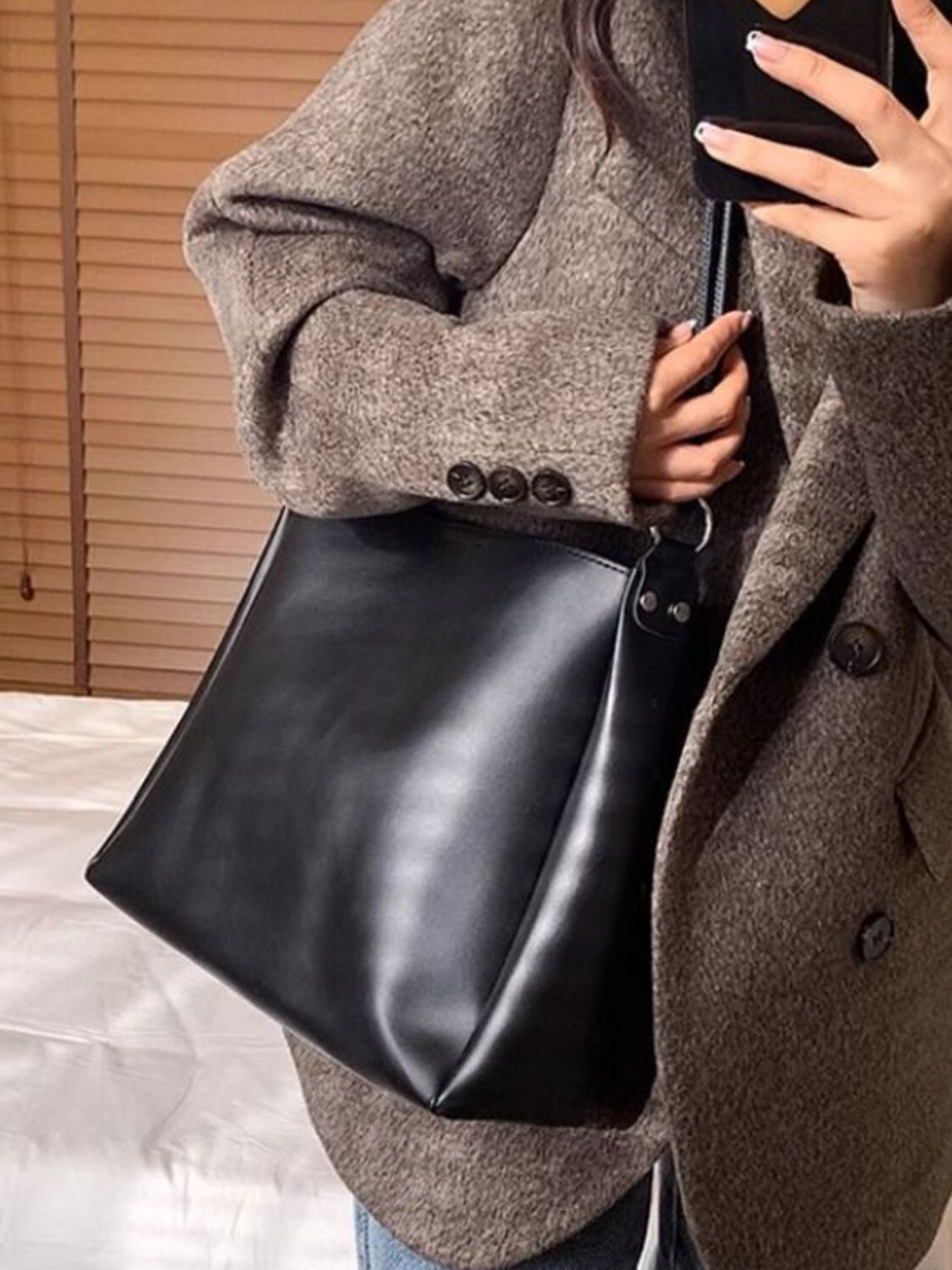 Structured PU leather shoulder bag slung over shoulder