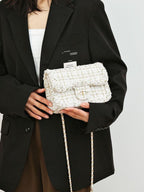 Classic tweed shoulder bag cradled in arm, showing size
