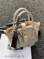 Structured mini satchel crossbody in ivory standing up on pavement