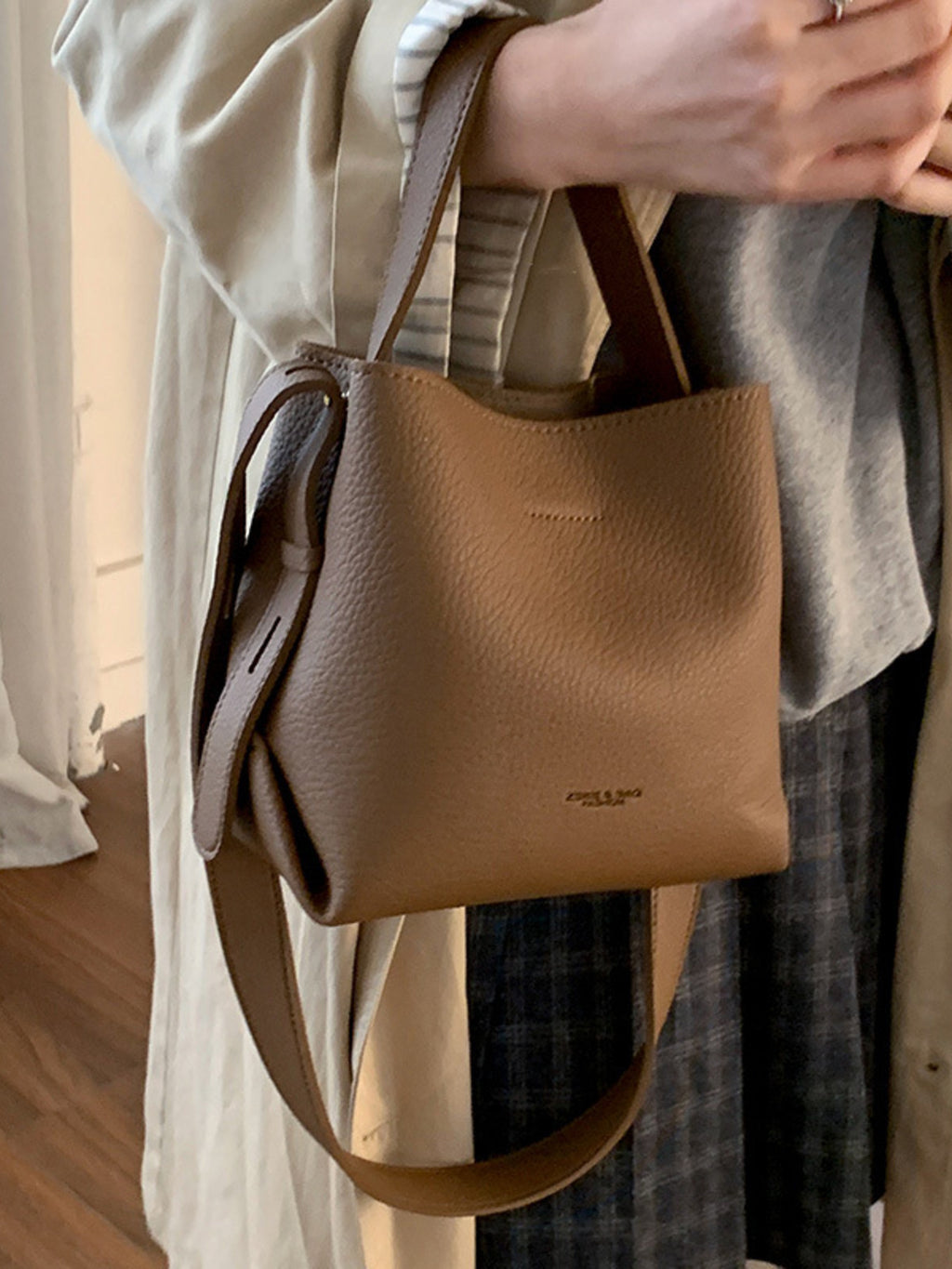 PU leather bucket crossbody bag hung on wrist