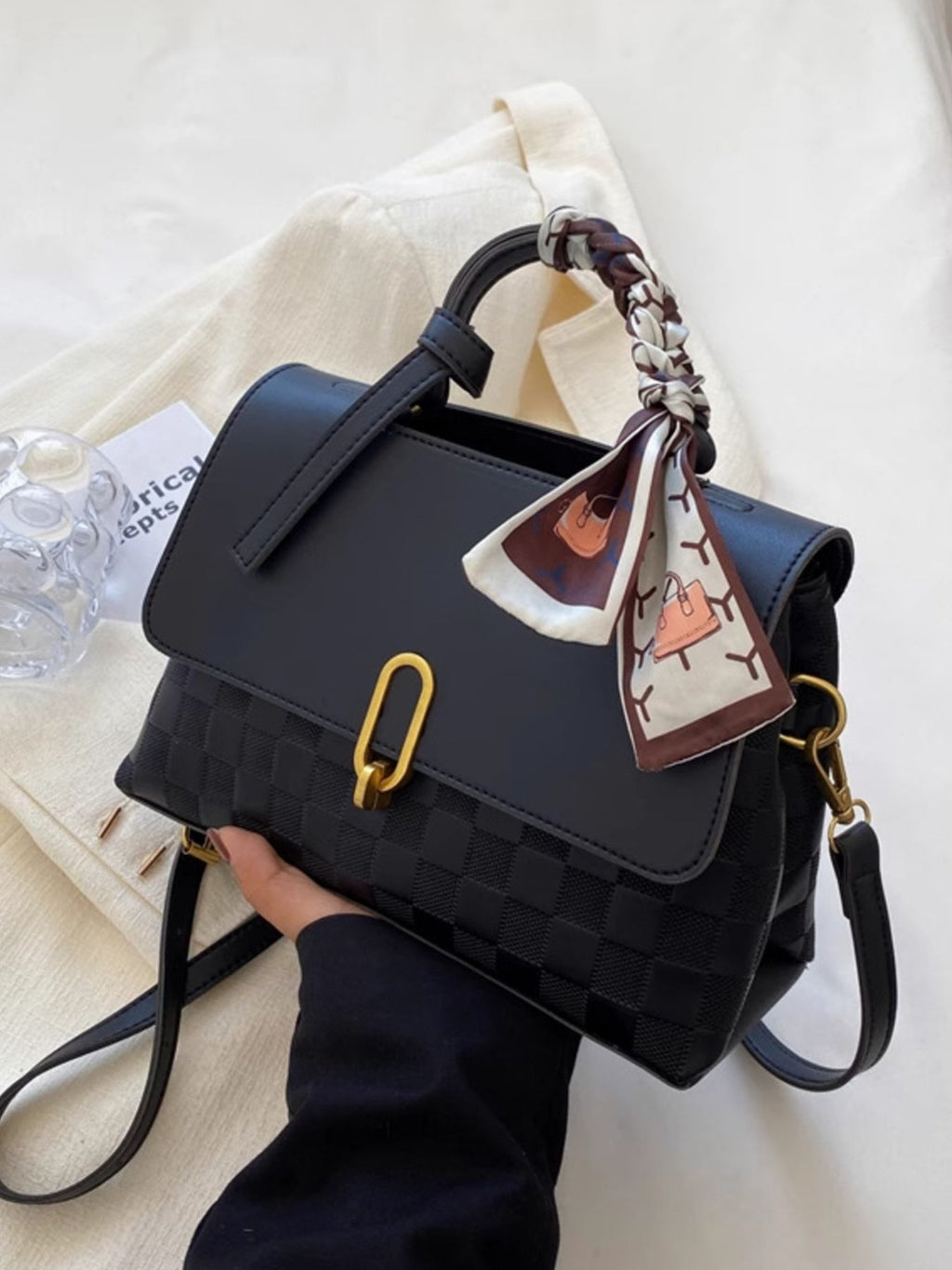 embossed crossbody bag held in hand