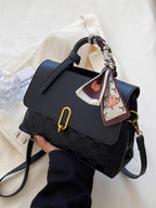 embossed crossbody bag held in hand